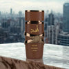 Lattafa Asad Bourbon Eau De Parfum 3.4 oz in elegant bottle against city skyline background.