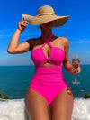 Crisscross halter one-piece swimsuit with wide-brimmed hat, showcasing elegant vacation style. Enjoy the sun, savor the sea view