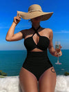Crisscross halter one-piece swimsuit with wide-brimmed hat, showcasing elegant vacation style. Enjoy the sun, savor the sea view