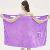 Adult wearing a purple wearable bath towel with bowknot design, featuring pockets and quick-drying coral velvet material.