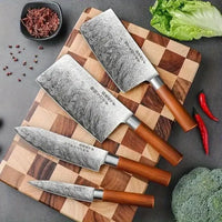 Set of four Japanese kitchen knives on a wooden cutting board, showcasing sharp stainless steel blades and wooden handles.
